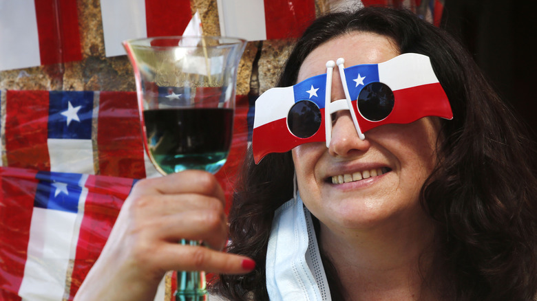 Woman holding wine glass with Chilean flag glasses