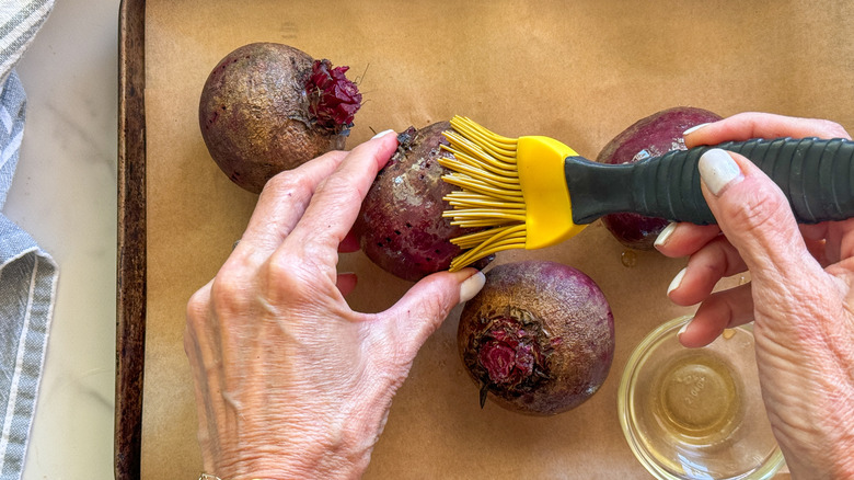 hand brushing beet with oil