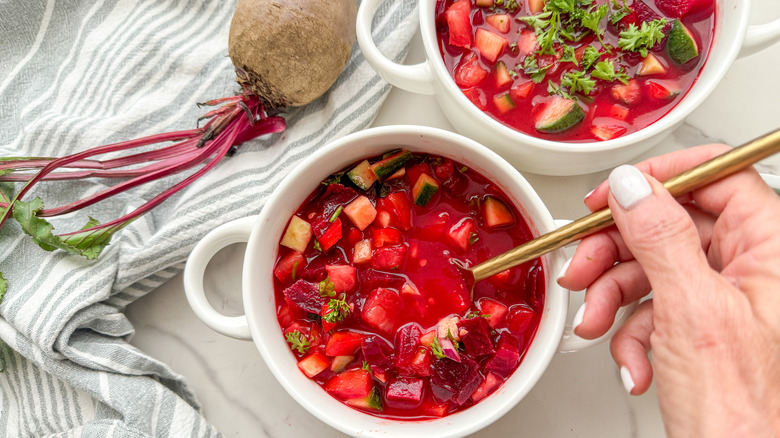 hand with spoon in soup