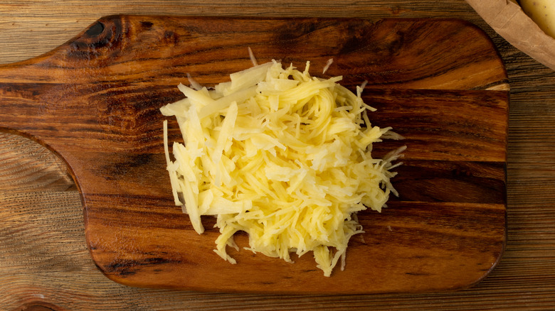 raw grated potato on cutting board