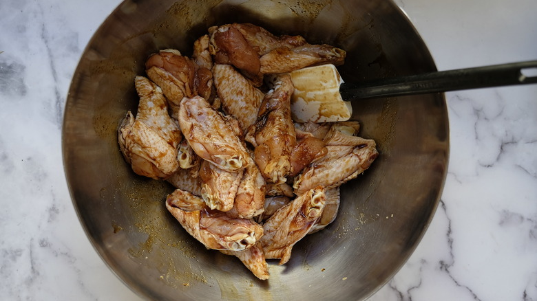 chicken wings marinating in wok