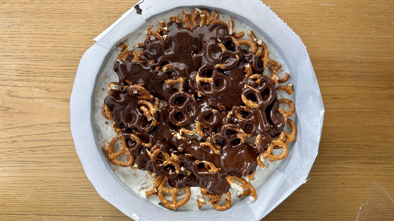 Melted chocolate poured over pretzel cake
