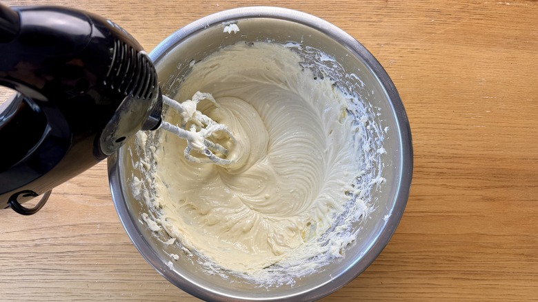 Mixing cream cheese filling in bowl