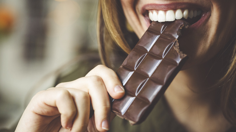 female eating chocolate bar