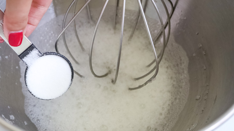 sugar being added to the bowl of a stand mixer