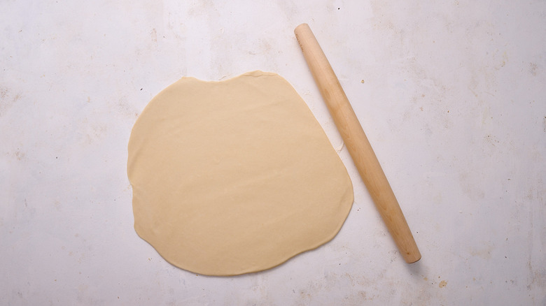 rolling dough out on table