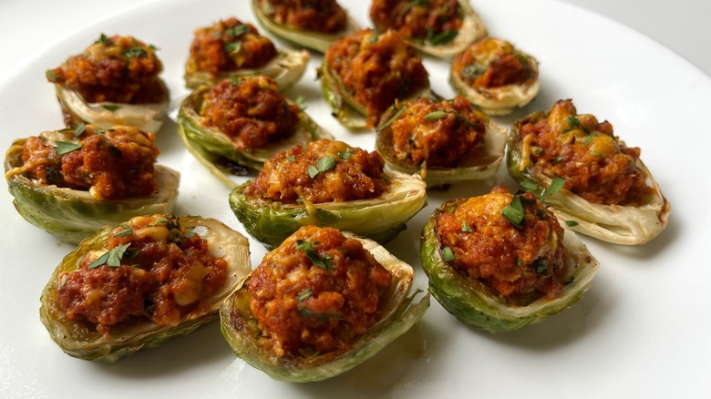 chorizo-stuffed brussels sprouts garnished with parsley on a plate