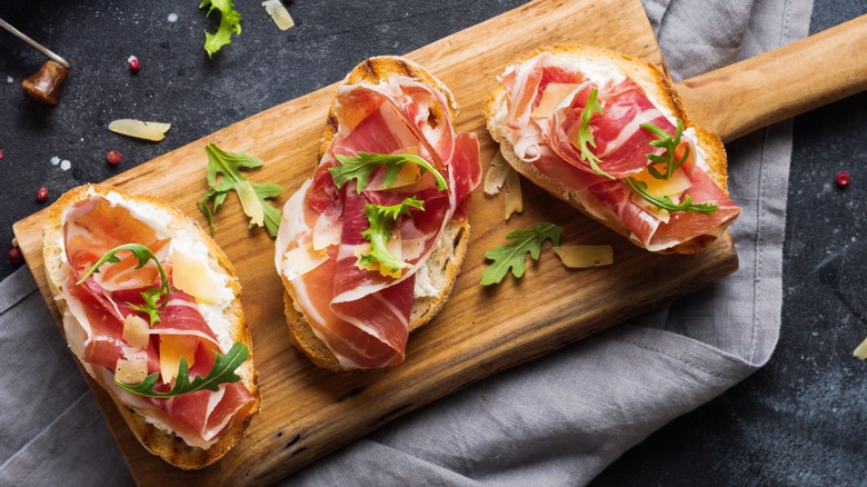 ciabatta bread topped with ham, cheese, and arugula