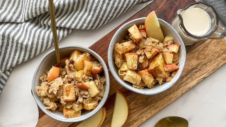 2 bowls of baked apple oatmeal on wooden board