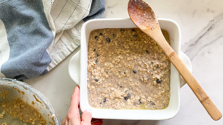 Oatmeal batter in pan with wooden spoon