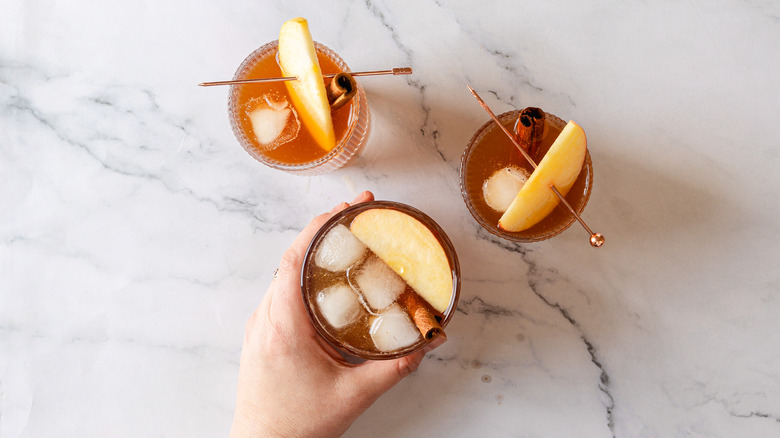 Hand holding one of three kombucha glasses