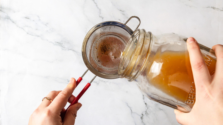 Pouring kombucha through strainer