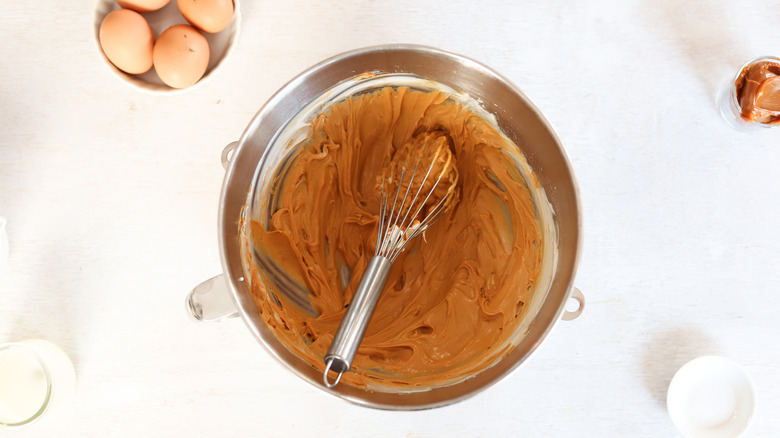 caramel cheesecake batter in bowl with whisk