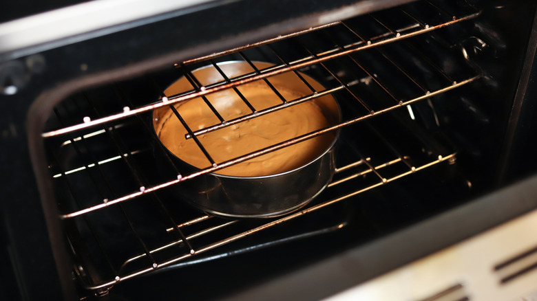 oven door propped open with cheesecake inside