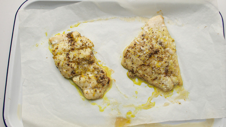 seasoned fish fillets on baking sheet