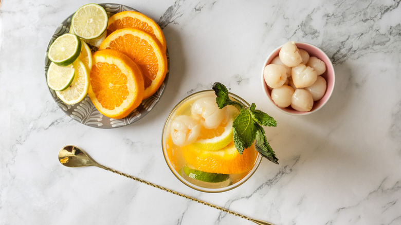 Overhead view of glass of sangria with pitcher and citrus in background