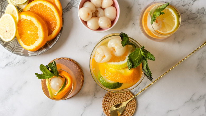 Overhead view of two glasses of sangria with pitcher and citrus in background