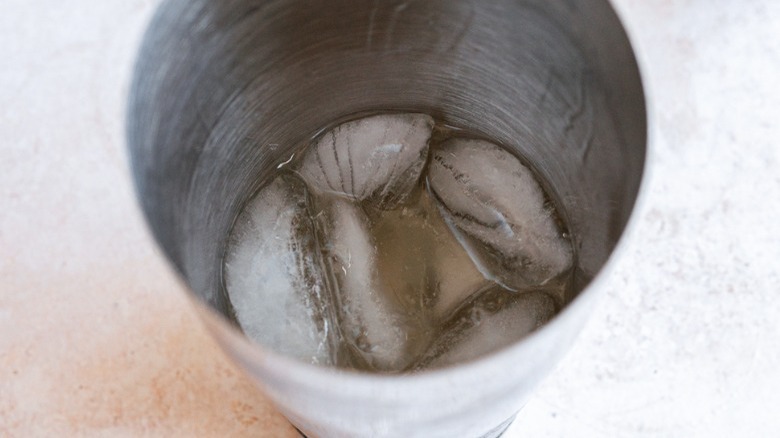 liquor and ice in cocktail shaker