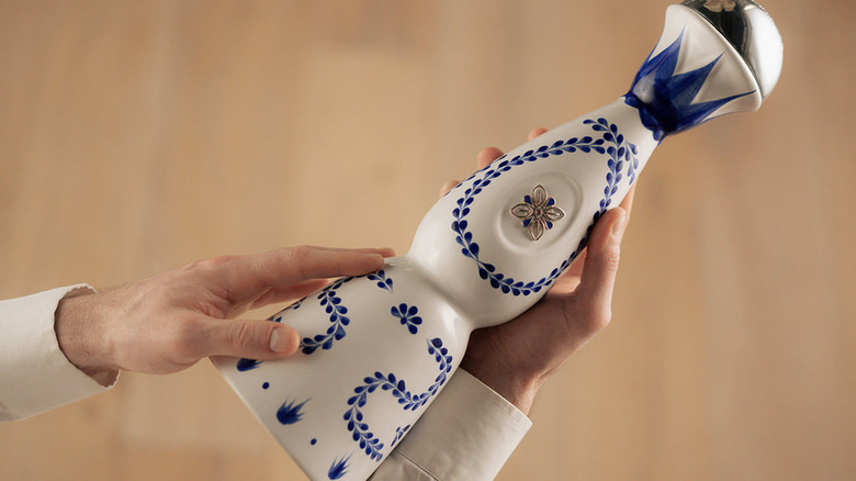 Holding Clase Azul Reposado bottle