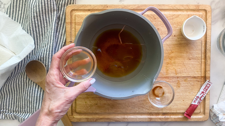 adding ingredients to pot for sauce