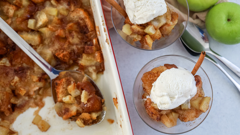 Casserole dish of apple brown betty with some individual servings