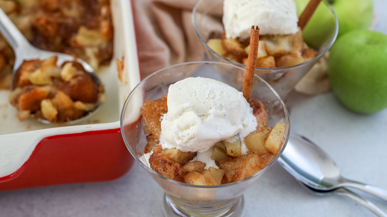 Apple brown betty in a dessert glass with ice cream on top