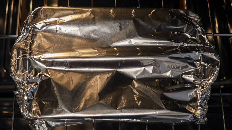 Foil-covered casserole dish in an oven