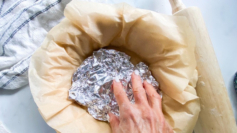 aluminum foil sitting in unbaked pie crust