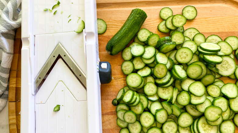 sliced cucumbers next to mandolin