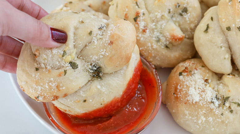 garlic knot dipping into marinara