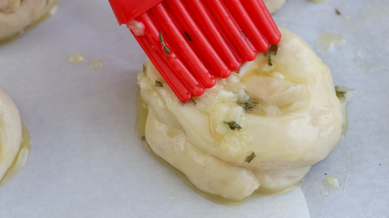 brushing butter onto garlic knot