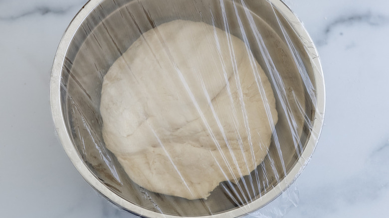dough in bowl covered with plastic