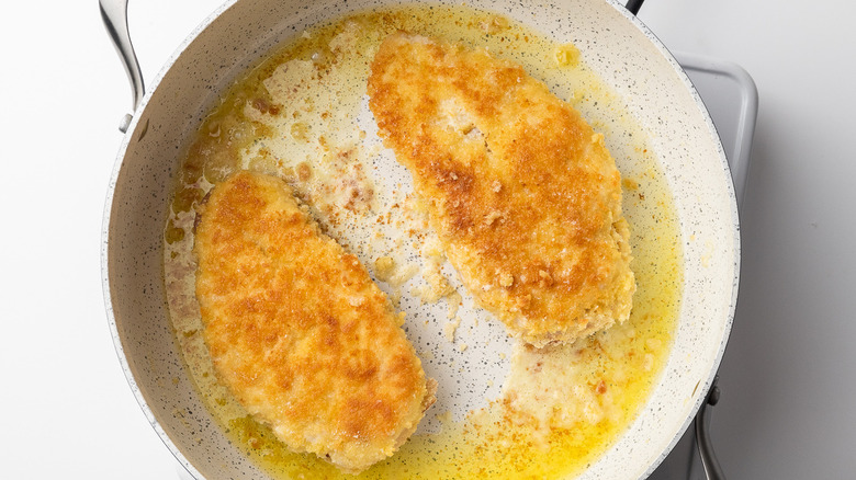 breaded chicken in frying pan 