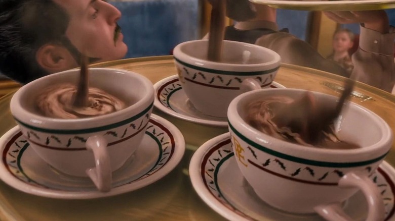 pouring hot chocolate into three cups