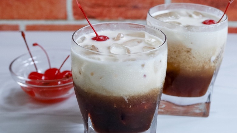 two cocktails with bowl of cherries