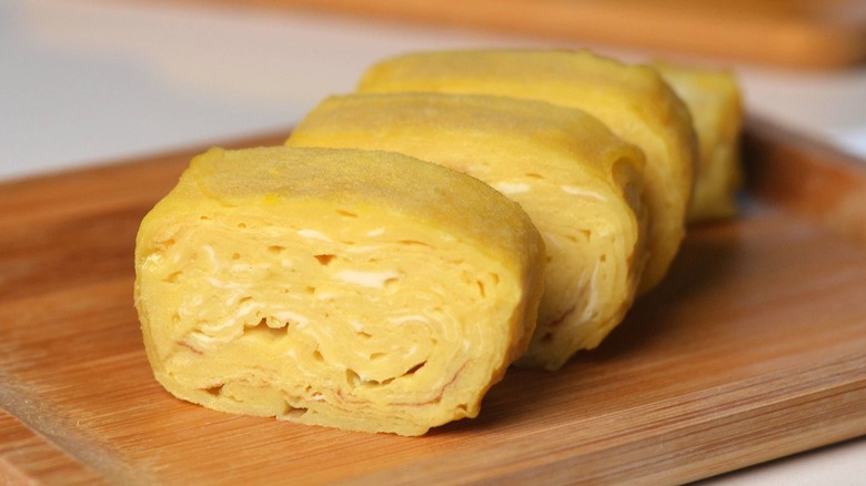 closeup sliced tamagoyaki on wood board