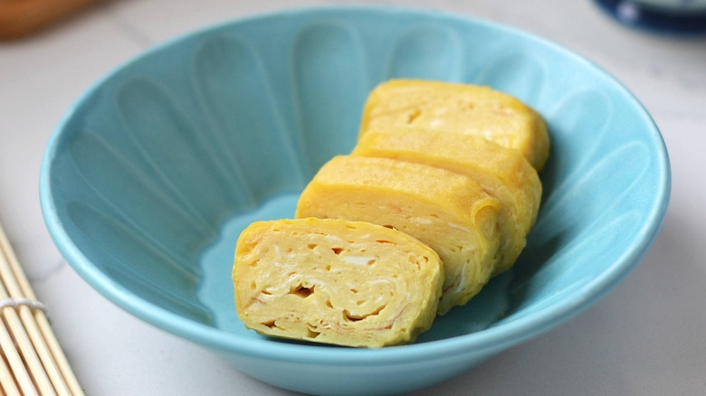 sliced tamagoyaki in blue bowl