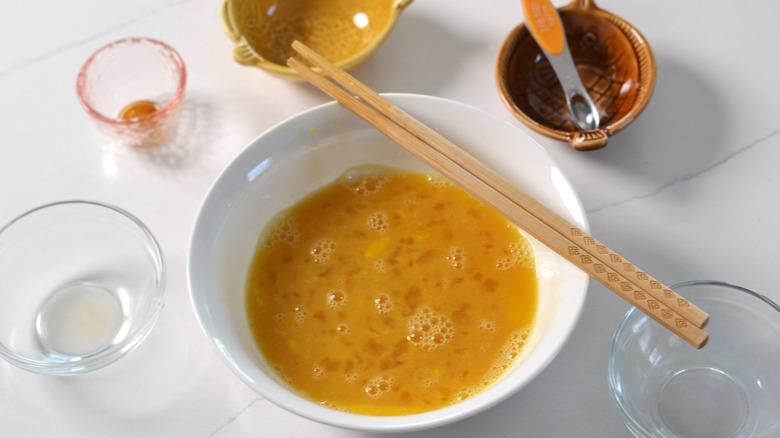 whisked eggs in bowl with chopsticks