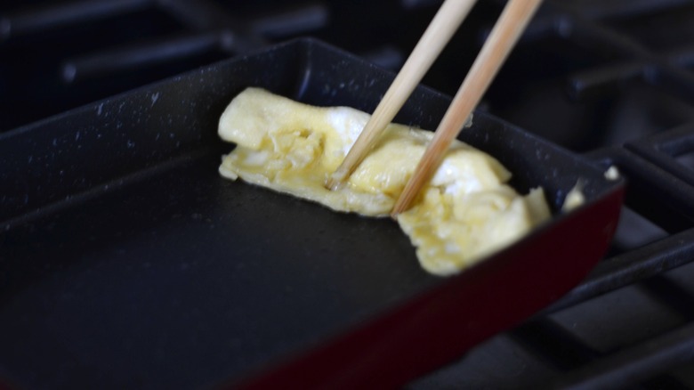 moving rolled egg with chopsticks