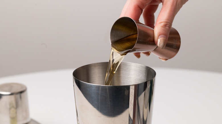 Pouring bourbon into cocktail shaker