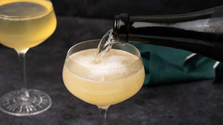 Pouring prosecco into a cocktail 