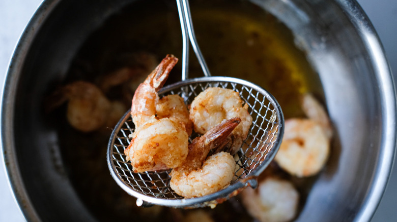 fried shrimp in slotted spoon