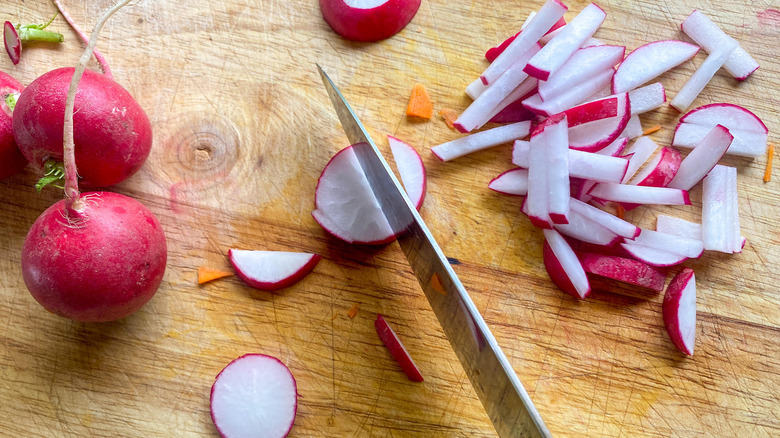 slicing radish on cutting board 