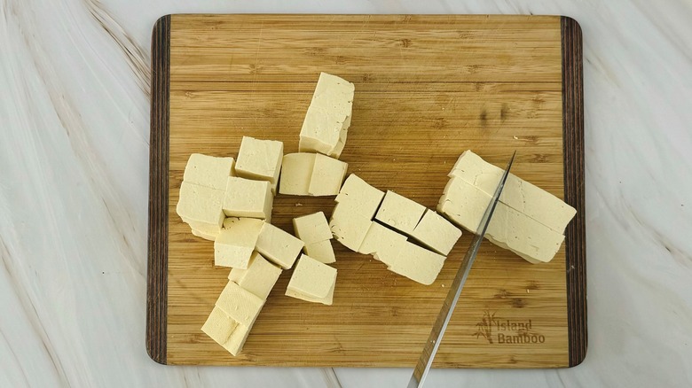 chunks of tofu with knife