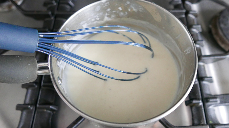 whisking the béchamel sauce