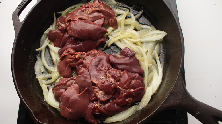 liver atop onions in a pan