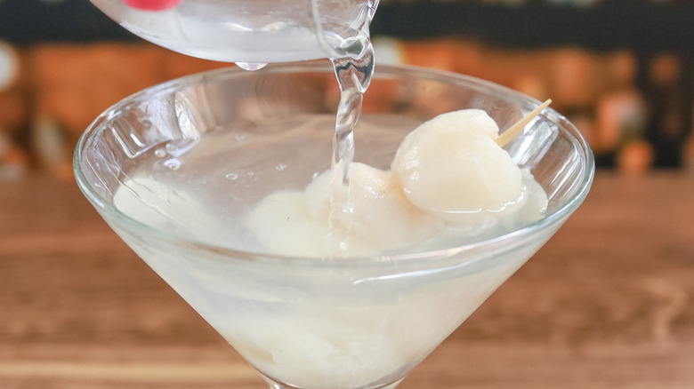 pouring strained drink into glass