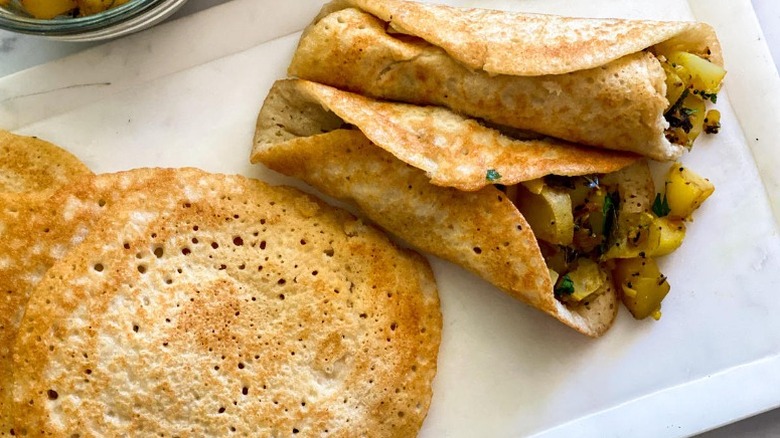 masala dosa on plate with extra dosa pancakes