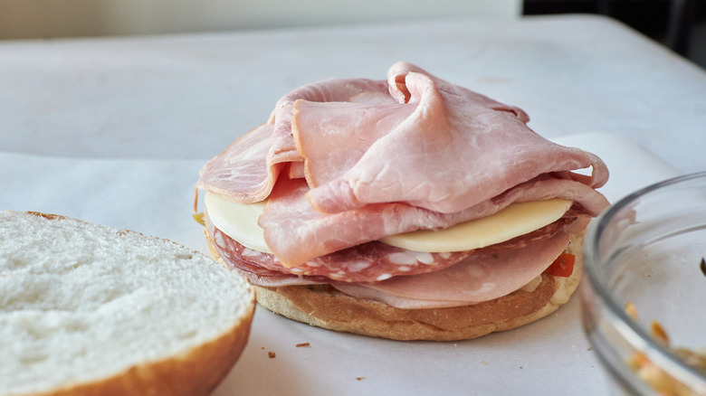 meats and cheese on bread on table