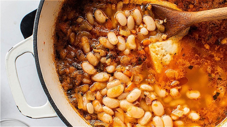 spoon stirring beans into soup